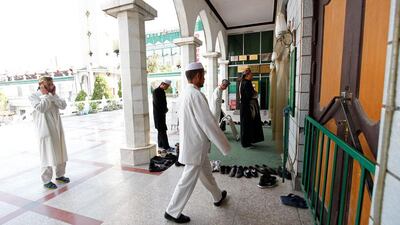 A Chinese Muslim sings the call to evening prayer as other men file into the Nanguan Mosque. Sarah Dea / The National