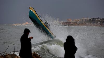 Palestinian fishermen ride their boat amid high waves on windy and rainy day at the sea in Gaza City, Sunday, Feb. 9, 2020. (AP Photo/Hatem Moussa)