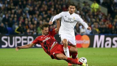 Real Madrid’s Cristiano Ronaldo (R) and Sevilla’s Grzegorz Krychowiak challenge for the ball during the UEFA Super Cup final soccer match at Cardiff City stadium, Wales, August 12, 2014. REUTERS/Dylan Martinez