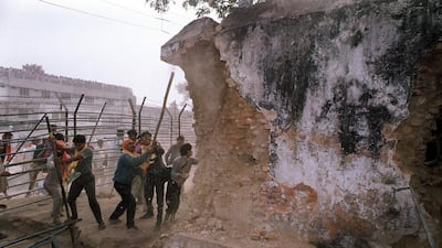 Indian Hindu fundamentalists attack the wall of the 16th century Babri mosque with iron rods at a disputed holy site in the city of Ayodhya on December 6, 1992. Three senior members of India's ruling Hindu nationalist party including a government minister should face trial over the demolition of a mosque a quarter of a century ago, the supreme court ruled on April 19, 2017. Douglas Curran/AFP