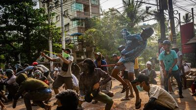 Anti-coup protesters use slingshots and throw stones at approaching security forces on March 28, 2021, in Yangon, Myanmar. Getty Images