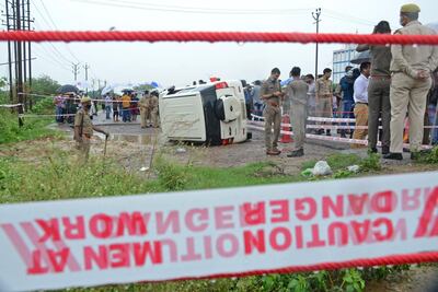 Indian policemen stand next to a vehicle that overturned while transporting crime suspect Vikas Dubey on July 10, 2020. The police say Dubey was shot dead while attempting to escape. AFP