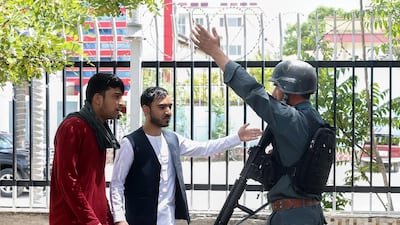 An afghan soldier keeps the people away from the scene of a bomb blast near the office of a Non-Government Organization and Attorney General's office, in Kabul, Afghanistan. EPA