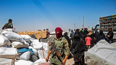 A member of Kurdish security watches preparations as another group of Syrian families is released from the Kurdish-run Al Hol camp. AFP