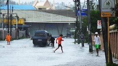 A child wades through a flooded road following the passage of Typhoon Kammuri in Legaspi City, Albay province, south of Manila. AFP