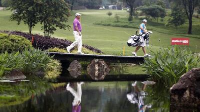 Lee Westwood, left, of England crosses a bridge during the final round of the Malaysian Open golf tournament. Lai Seng Sing / AP / April 20, 2014