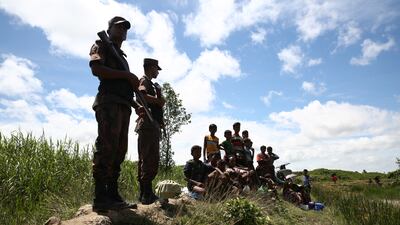Bangladeshi border guard personnel keep watch over Rohingya, as they stop them from crossing over to the Bangladesh side of the border at Ghumdhum, Cox's Bazar, Bangladesh, on August 27, 2017. Mushfiqul Alam/AP Photo