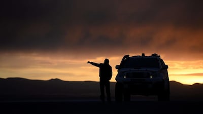 Dakar Rally director Etienne Lavigne gestures during the sunset in Uyuni last week while he and staff scout locations for the 2015 race. Franck Fie / AFP / September 18, 2014
