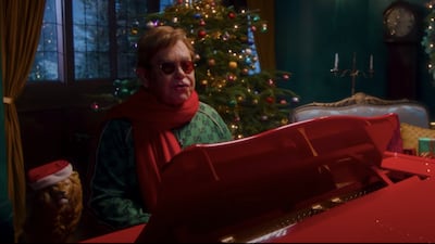 Elton John, wearing a green Gucci tracksuit, in the 'Merry Christmas' music video, which debuted on December 3, 2021. Photo: YouTube