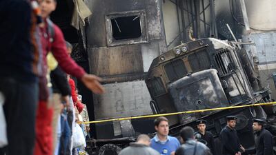 Security forces and onlookers gather at the scene of a fiery train crash at the Egyptian capital Cairo's main railway station. AFP