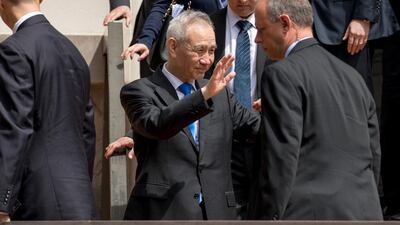 China’s chief negotiator in the talks Liu He waves to the media as he departs the Office of the United States Trade Representative in Washington. AP