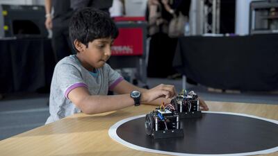 @A visitor plays with robots, at one of the stalls. Rashed Al Mansouri / Crown Prince Court - Abu Dhabi