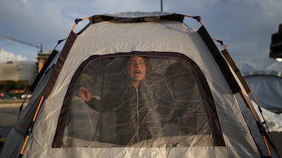 A displaced girl calls her sister from inside a tent at a makeshift camp during a temporary ceasefire between Lebanon and Israel, in Beirut. Reuters