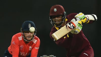 England's wicketkeeper Jos Butler, left, looks on as West Indies's Marlon Samuels plays a shot during the World T20 cricket final match at The Eden Gardens Cricket Stadium in Kolkata on April 3, 2016. AFP / INDRANIL MUKHERJEE