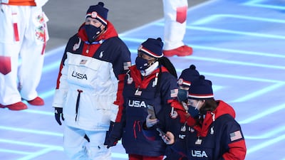 Women athletes for Team USA walk during the opening ceremony of the 2022 Beijing Olympics wearing red boots and red trousers with navy jackets, designed by Ralph Lauren. Getty Images