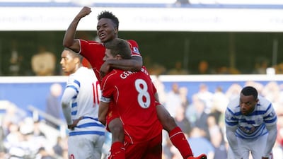 Liverpool’s Raheem Sterling, top, celebrates with Steven Gerrard after his cross was deflected into the QPR goal on Sunday. Eddie Keogh / Reuters