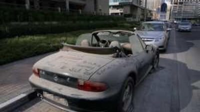 A BMW Z3 sports car wasting away on a side street in Dubai Marina area.