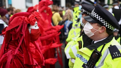 The Extinction Rebellion 'Red Rebel Brigade' face off with police officers by London Bridge. Reuters