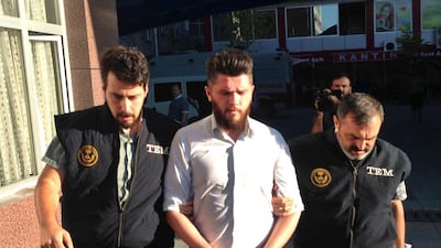 Turkish police officers escort a man arrested in a raid in Konya on Wednesday. AP / Tolga Yanik