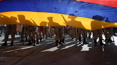 Members of the Bolivarian militia attend a march in support of Venezuelan President Nicolas Maduro with a Venezuelan national flag in Caracas.