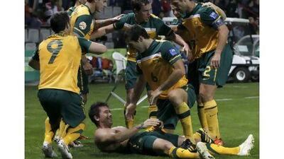 Harry Kewell, on ground, and his teammates celebrate his late winner against Iraq.