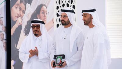 Sheikh Mohamed bin Zayed presents an award for Mohamed Khalifa Al Mubarak, Chairman of the Department of Culture and Tourism and Abu Dhabi Executive Council Member (centre), on behalf of Aldar Properties for participating in Sandooq Al Watan, during a Sea Palace barza. They are seen with Lt General Dhahi Khalfan Tamim, Chairman of the Board of Directors at Sandooq Al Watan (left). Ryan Carter for the Ministry of Presidential Affairs