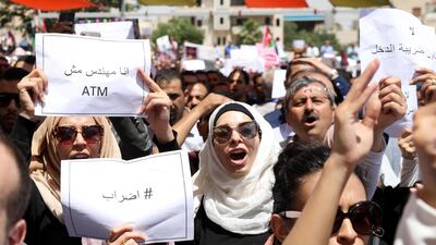 Jordanians hold placards and shout slogans against the newly proposed income tax reforms during the first general strike to take place in Jordan in 20 years. Andre Pain / EPA