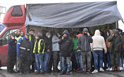 Drivers shelter from the rain as they block the road by the entrance to the port in Dover in protest against a blockade. AFP.