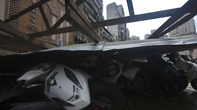 A large piece of corrugated iron is seen after falling on parked motorbikes on a pavement in Macau on August 24, 2017. Anthony Wallace / AFP