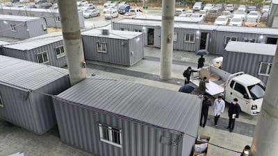 Workers move equipments into containers set up as a makeshift medical facility to accommodate COVID-19 patients at a hospital's grounds in Daegu, South Korea. AP
