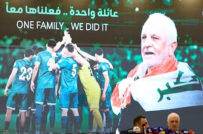 The words 'one family ... we did it' appear on the screen as Graham Arnold attends a pre-World Cup press conference in Baghdad. Reuters