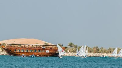 Olympic-style sailboats cruise the waters in Abu Dhabi on Wednesday near a dhow ahead of the 2015 ISAF Sailing World Cup Final beginning on Thursday. Jesus Renedo / Sailing Energy / ISAF