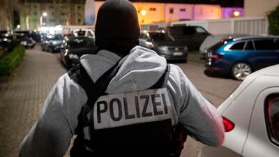 A police officer guards the road in front of a house that is searched through by police in Hanau, Germany. AP
