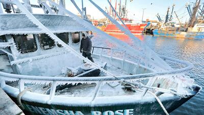 Captain Mike Oliveira walks across the frozen bow of the Menemsha Rose crab boat, in preparation to unload its catch at Liberty Lobster in New Bedford, Massachusetts, United States. AP Photo