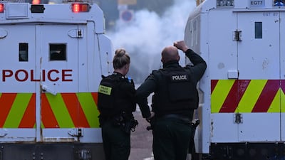 Police officers take cover from protesters. Getty Images