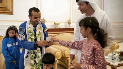 Sheikha Fatima bint Mohamed bin Hamad Al Nahyan gives Hazza Al Mansouri a note. Seen with Sheikh Hazza bin Zayed. Hamad Al Kaabi / Ministry of Presidential Affairs