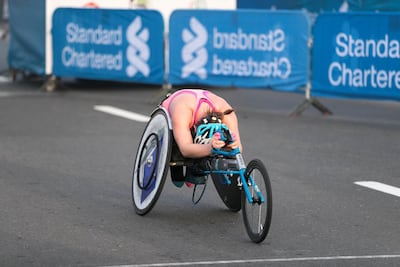 An athlete arrives at the finish line of Standard Chartered Dubai Marathon Wheelchair race. Reem Mohammed / The National