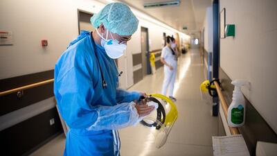 A doctor wipes his protective visor after visiting a Covid-19 room. Getty Images