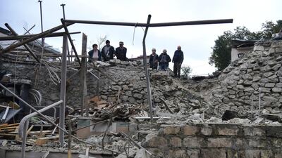 Men look at the damage in a residential area after shelling by Azerbaijan's artillery during a military conflict in self-proclaimed Republic of Nagorno-Karabakh, Stepanakert, Azerbaijan. AP
