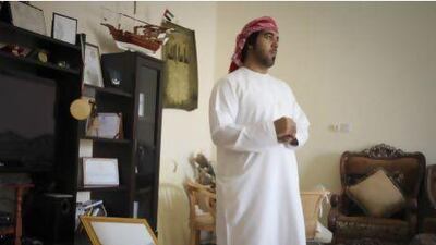 Mohammed Abdullah Al Shehhi, 24, stops for a pensive moment at the Majlis in his father's home. Mohammed is a proponent of maintaining the Shehhi dialect and converses with most of his friends in Shehhi when sitting around the Majlis. Razan Alzayani / The National