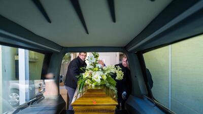 Employees of Lantz funeral directors carry a coffin containing a corpse infected by the Covid-19 into a hearse in Mulhouse, eastern France. AFP