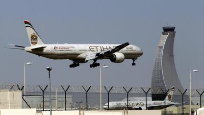 An Etihad Airways plane prepares to land at Abu Dhabi's airport. The carrier is one of the first airlines globally to launch the Iata Travel Pass. AP