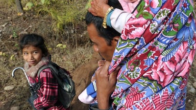 Chandra Bahadur Dangi (R), a 72-year-old Nepali who claims to be the world's shortest man at 56 centimetres (22 inches) in height, is carried by his nephew Dolak Dangi on the way to his home village in Dang district, some 540 kilometres southwest of Kathm???