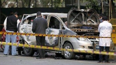 Indian security and forensic officials examine a car belonging to the Israel embassy after an explosion in New Delhi.
