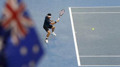 Japan's Kei Nishikori hits a shot as a spectator holds an Australian national flag during his quarter-final match against Serbia's Novak Djokovic at the Australian Open tennis tournament at Melbourne Park, Australia, January 26, 2016. REUTERS/Brandon Malone