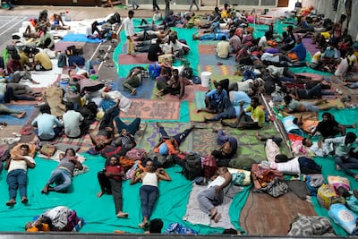 People evacuated from Kandla port, in preparation of Cyclone Biparjoy, rest at a shelter in Gandhidham, India, on Tuesday. AP