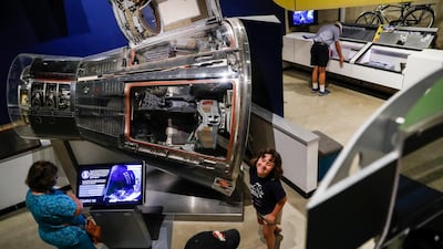 Visitors browse an exhibit featuring the Gemini VIII spacecraft.