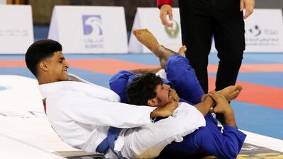 Khalifa Nassrati ( white ) of Al Ain Jiu-Jitsu Club and Abdul Rehman Alawlqi ( blue ) of Al Wahda Club during the Final game of junior under 21 category in the Jiu-Jitsu President’s Cup Round -1 held at Al Jazira Club Indoor stadium in Abu Dhabi. Khalifa Nassrati won the final game. Pawan Singh / The National