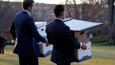 Aides carry boxes to Marine One before President Donald Trump leaves the White House. AP Photo