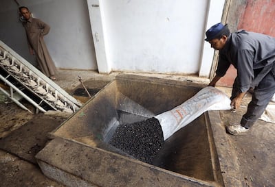Olives are placed into a machine during the production of olive oil in the Libyan town of Tarhuna (80 kms) south of Tripoli, on November 11, 2018. AFP